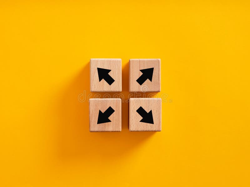 Decision making and choosing the right path. Dysfunctional team, diversity and opposition. Team disunity and separation. Arrow icons on wooden cubes moving to opposite directions. Decision making and choosing the right path. Dysfunctional team, diversity and opposition. Team disunity and separation. Arrow icons on wooden cubes moving to opposite directions