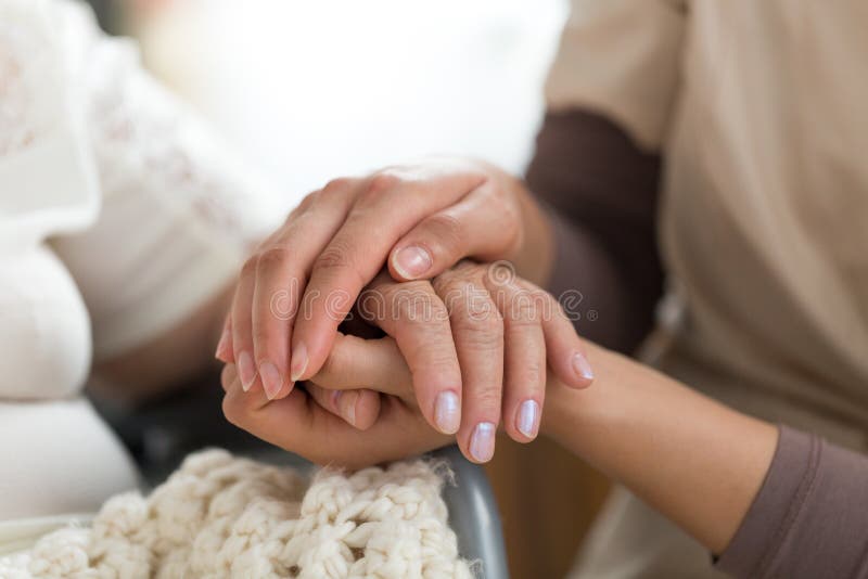 Pflegekraft, die ältere Frau ` s Hände hält