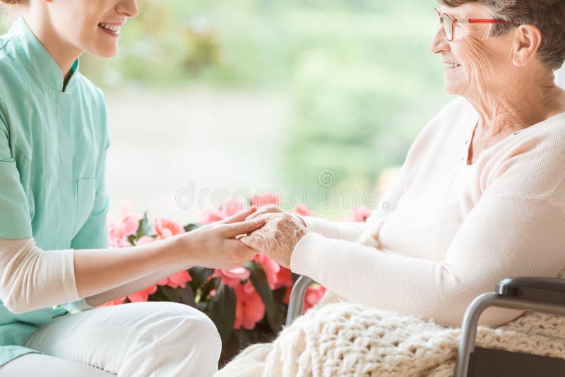 Pflegen Sie das Vorbereiten eines behinderten Pensionärs für einen Weg im Garten von lizenzfreies stockbild Pflegen Sie das Vorbereiten eines behinderten Pensionärs für einen Weg im Garten von lizenzfreies stockbild