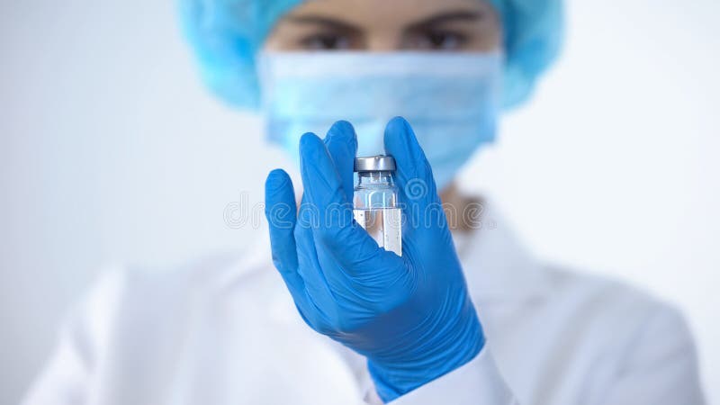 Pflegen Sie in der Maske, die Flasche mit Impfstoff, neue Drogenforschung, illegales Doping hält stockfotos Pflegen Sie in der Maske, die Flasche mit Impfstoff, neue Drogenforschung, illegales Doping hält stockfotos
