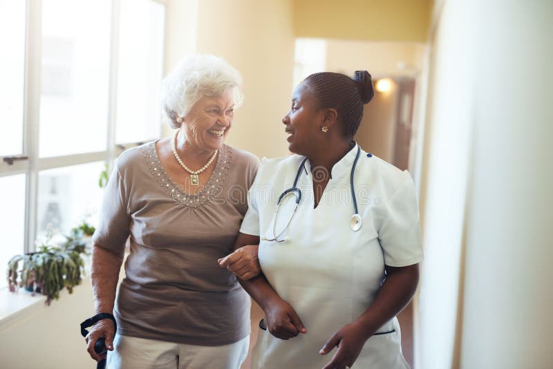 Pflegen Sie die Unterstützung der älteren Frau an Krankenpflege homeSenior Frau, die in das Pflegeheim geht, das von einer Pflege
