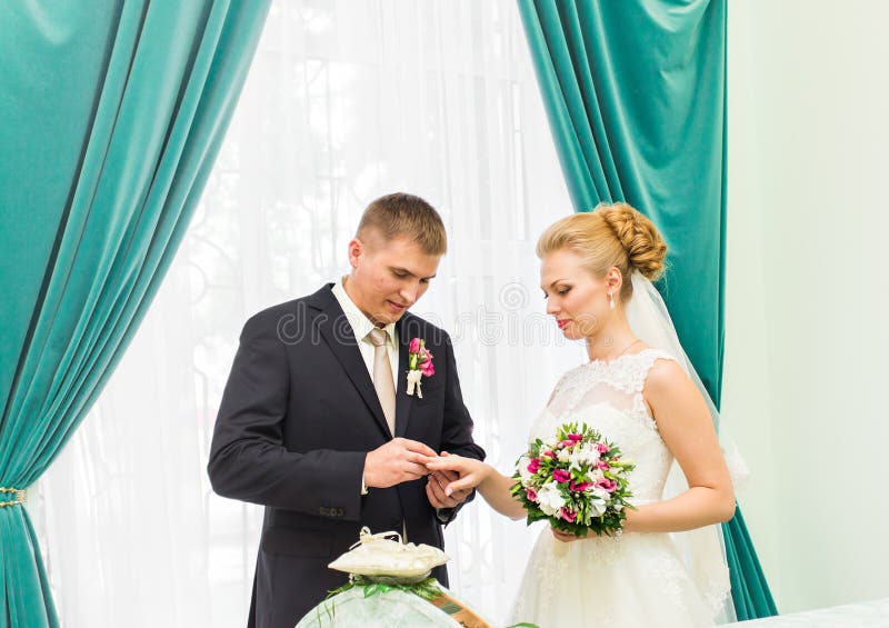 Pflegen Sie Rutschring auf Finger der Braut an der Hochzeit lizenzfreie stockfotos Pflegen Sie Rutschring auf Finger der Braut an der Hochzeit lizenzfreie stockfotos
