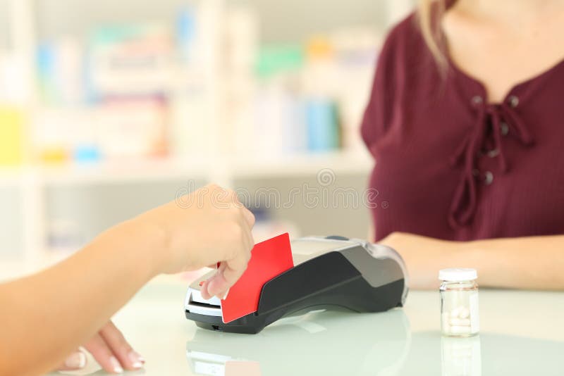 Pharmacien chargeant de la carte de crédit dans une pharmacie images libres de droits Pharmacien chargeant de la carte de crédit dans une pharmacie images libres de droits