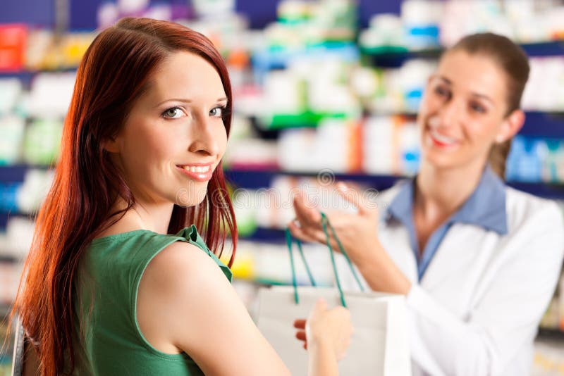 Pharmacien féminin dans sa pharmacie avec un propriétaire image libre de droits Pharmacien féminin dans sa pharmacie avec un propriétaire image libre de droits