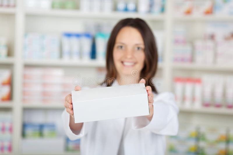 Pharmacien féminin Holding White Box à la pharmacie photo stock Pharmacien féminin Holding White Box à la pharmacie photo stock