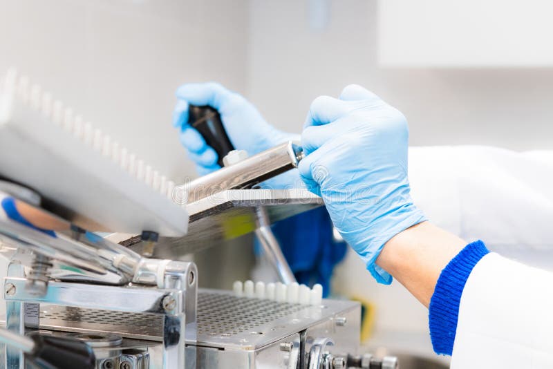 Pharmacist Working in Laboratory with Encapsulator Machine Stock Image