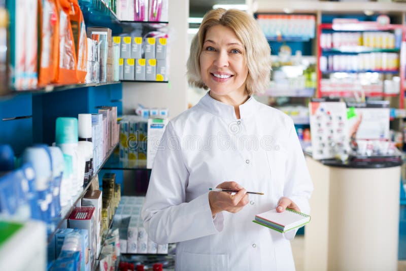 Portrait of mature smiling female pharmacists working in modern farmacy