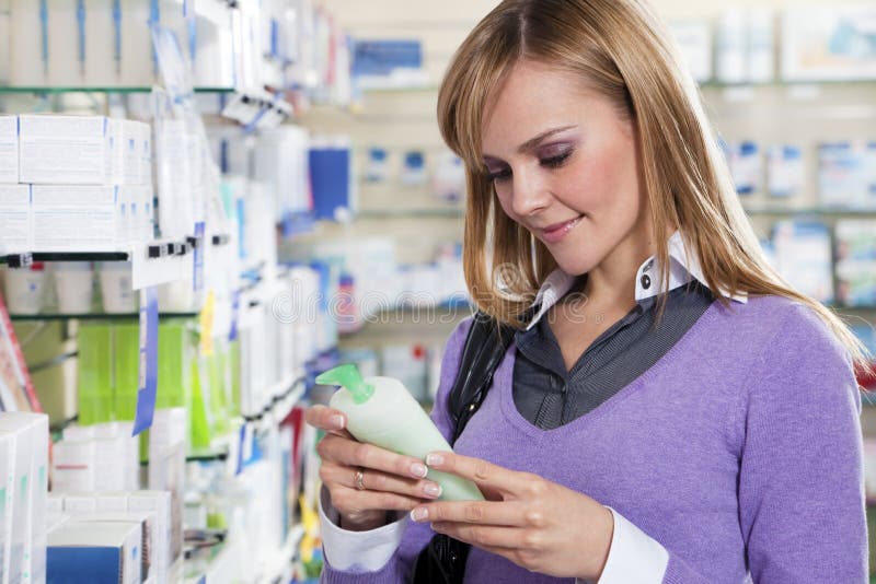 Retrato rubio una mujer lectura etiqueta de champú en farmacia.