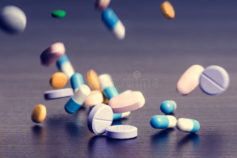 Pharmacy background on a dark table. Levitation pills. Tablets on a dark background which falling down. Pills. Medicine and health