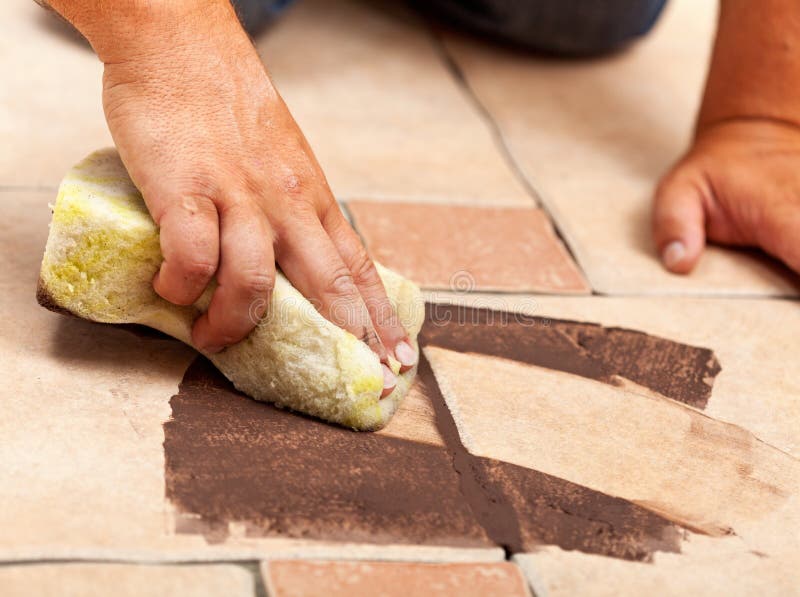Phases of installing ceramic floor tiling - the joint material royalty free stock image
