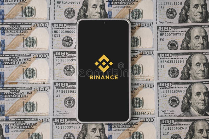 Phone and Binance logo and dollars. Binance is a cryptocurrency exchange stock photography