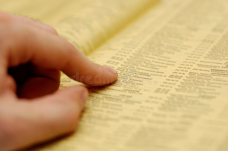 Phone book. Hand and phone book - looking for a number Phone book. Hand and phone book - looking for a number