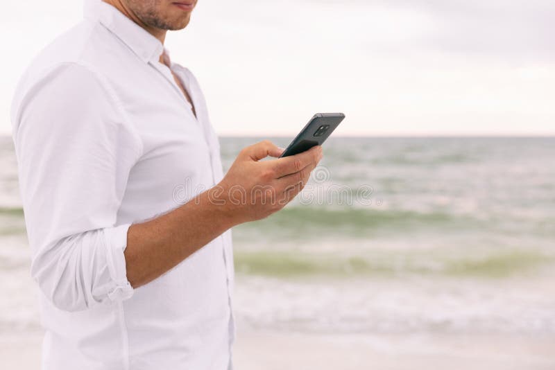 Phone business man hand holding smartphone texting sms text message online using app. Businessman on beach cellphone