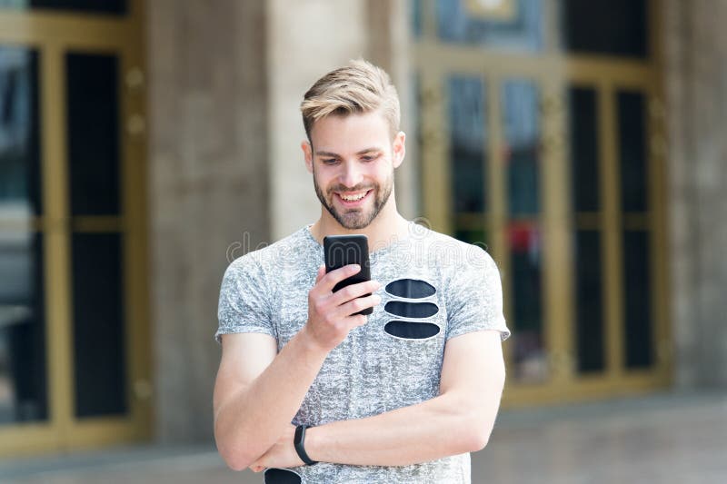 Phone created for those who live on edge. Happy man talking on mobile phone on urban outdoor. Caucasian hipster using stock photos Phone created for those who live on edge. Happy man talking on mobile phone on urban outdoor. Caucasian hipster using stock photos
