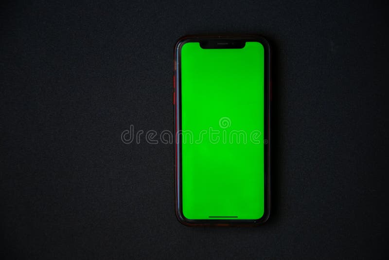 The Phone with a Green Screen is on a Black Background. Stock Photo