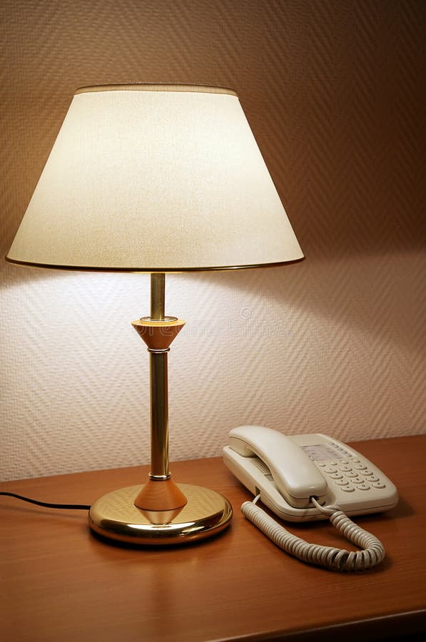 Phone on a table near to a lamp. Phone on a table near to a lamp