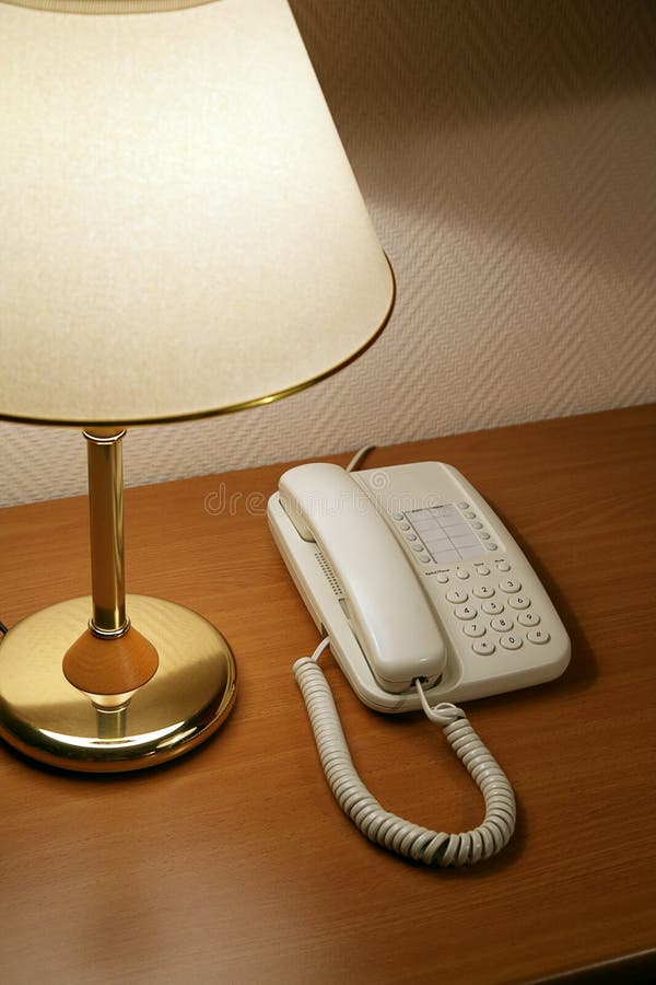 Phone on a table near to a lamp. Phone on a table near to a lamp