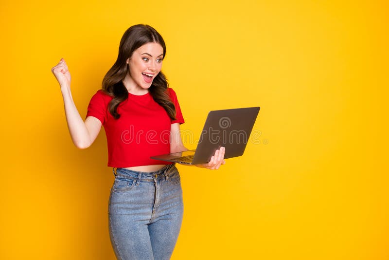 Photo of amazed girl work laptop deal aim win raise fists wear red t-shirt isolated bright shine color background