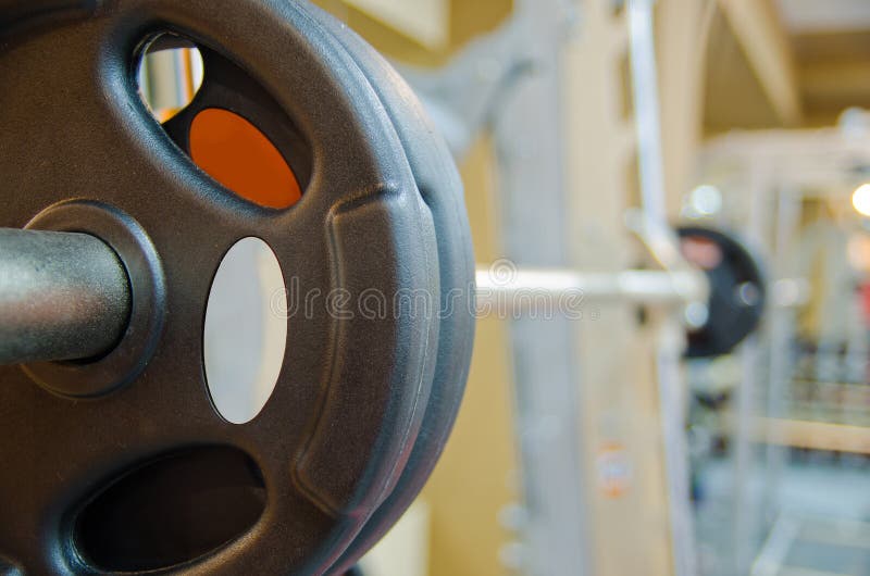 Photo of barbell on a rack in training room. Photo of barbell on a rack in training room