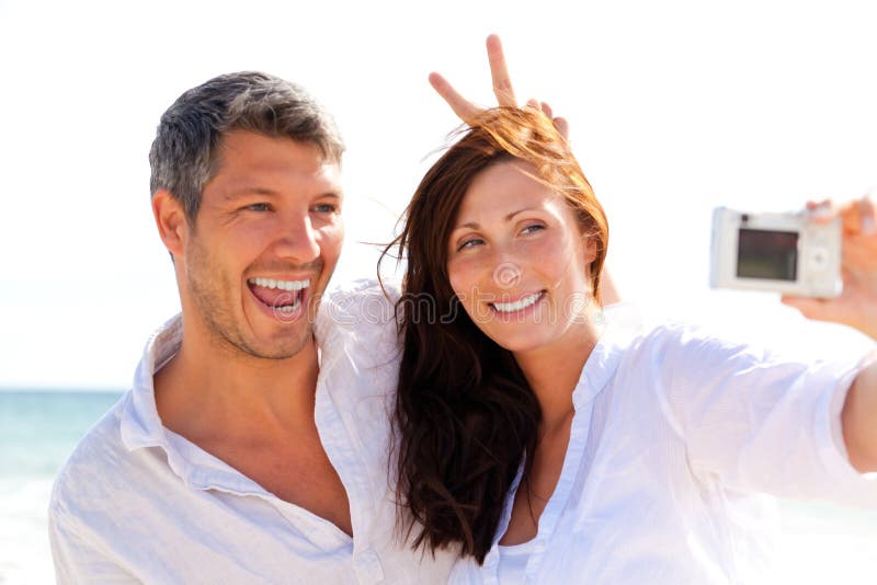 Summer couple taking self portrait photo on the beach. Summer couple taking self portrait photo on the beach