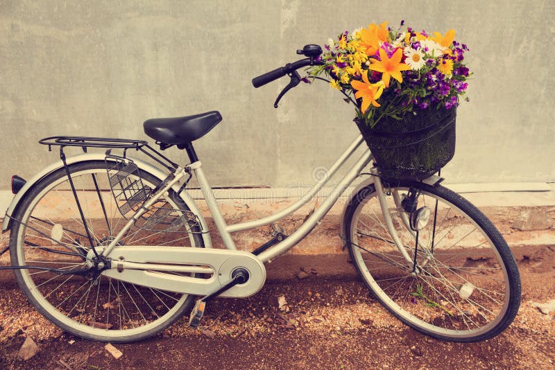 Photo of a bicycle with a basket full of field flowers