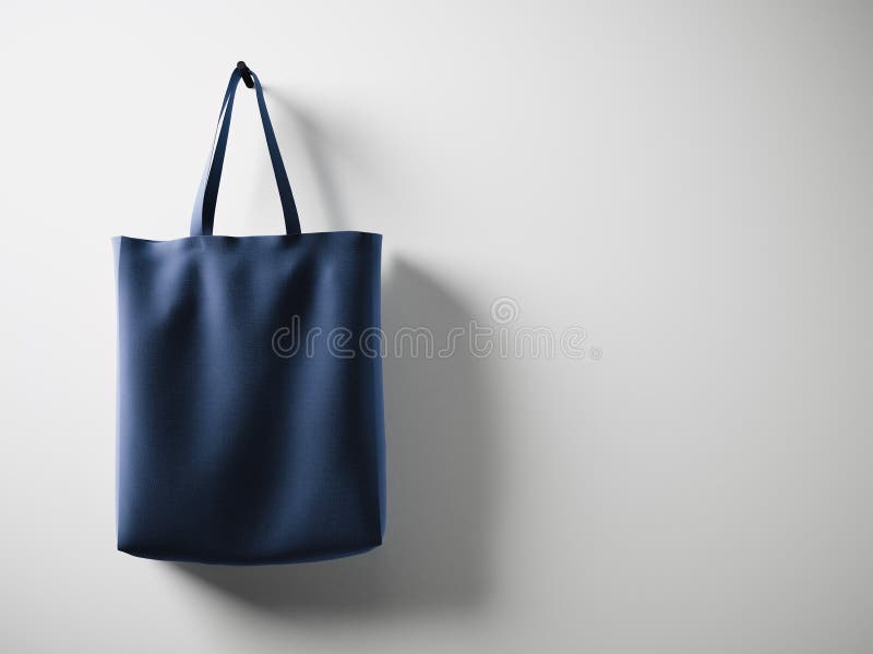 Photo blue cotton textile bag hanging left side. Empty white wall background. Highly detailed texture, space for royalty free stock photo