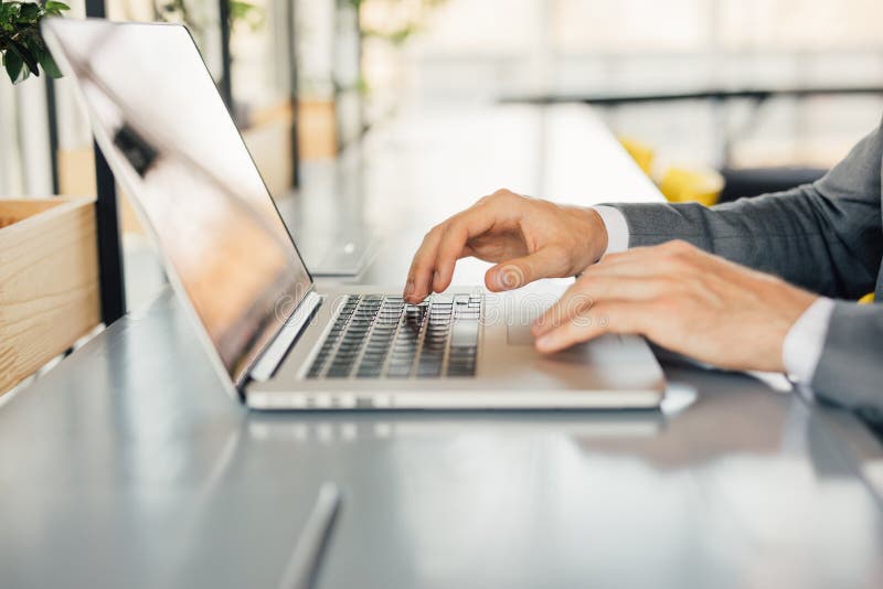 Photo businessman working on modern loft office. Man sitting wood table and using contemporary notebook, texting message keyboard. royalty free stock photography Photo businessman working on modern loft office. Man sitting wood table and using contemporary notebook, texting message keyboard. royalty free stock photography