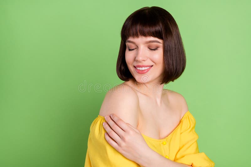 Photo of calm peaceful charming happy young woman touch hand shoulder skin isolated on green color background