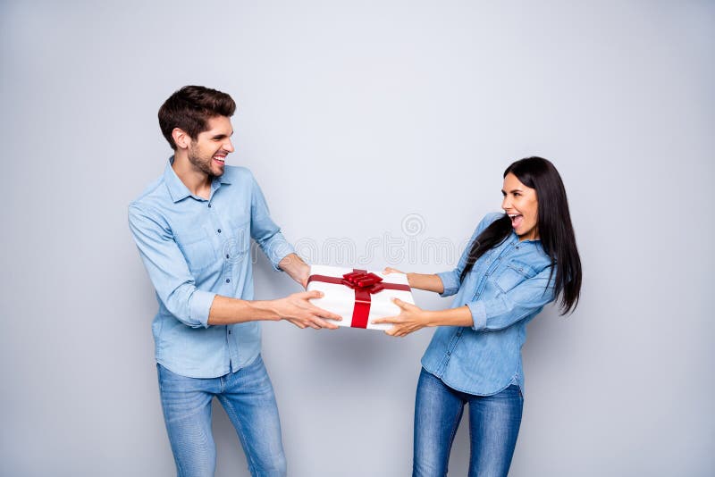Photo of cheerful trendy stylish white couple of two people together contesting about who will obtain the giftbox. Photo of cheerful trendy stylish white couple stock photo