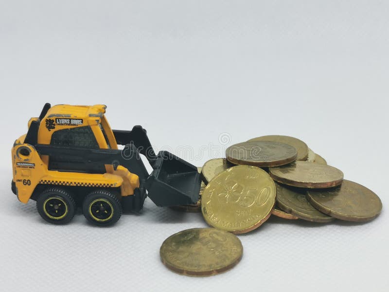 Photo of coin and miniature skid steer truck isolated on white background.