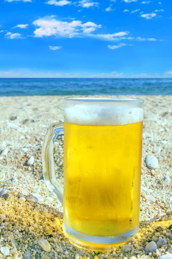 Photo of Cold Beer Bottle in the Sand on the Beach Stock Photo Image
