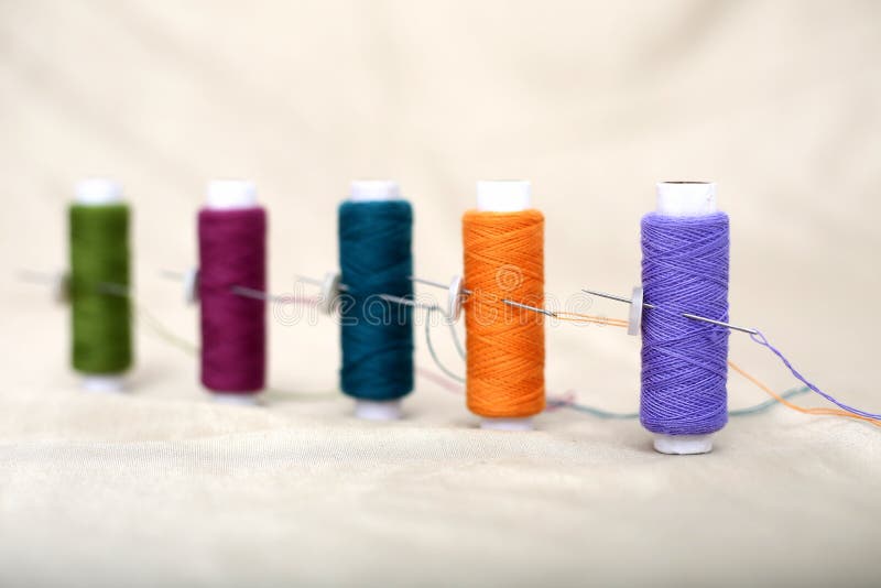 Photo of colored sewing thread and needle on the cloth stock photography