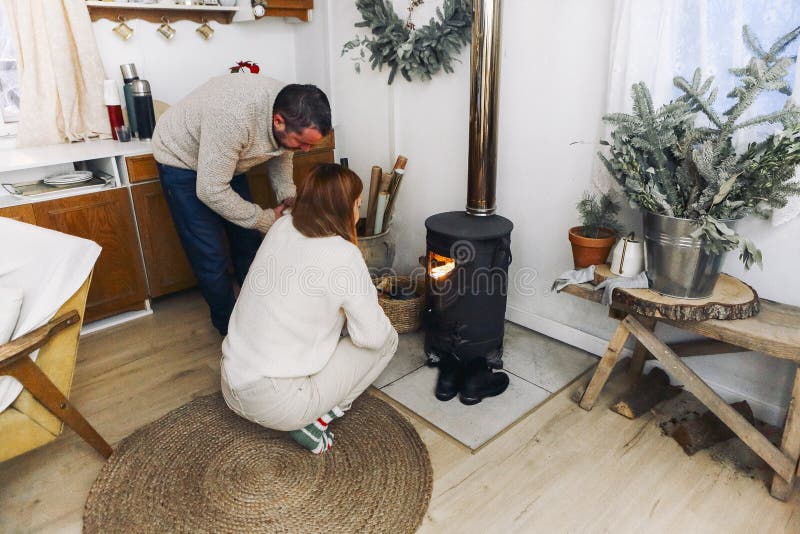 Photo of coule in warm woolen socks over fire place. Hygge concept of cozy winter weekend in cabin