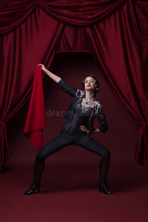 Photo d'art de jeune femme de mode sur l'étape avec les rideaux rouges photo libre de droits Photo d'art de jeune femme de mode sur l'étape avec les rideaux rouges photo libre de droits