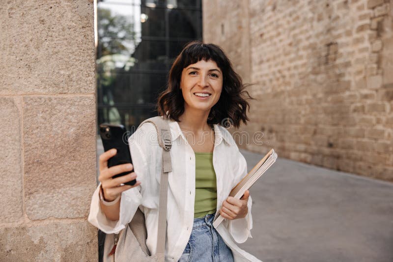 Photo d'une jolie femme brune faisant du selfie et tenant des carnets photos stock