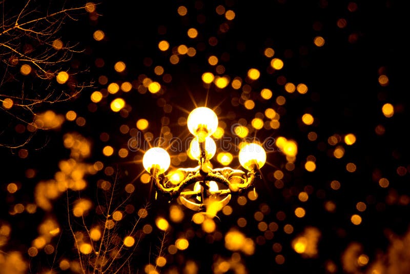 Photo d'une lanterne antique avec la lumière jaune et les rayons la nuit photographie stock Photo d'une lanterne antique avec la lumière jaune et les rayons la nuit photographie stock