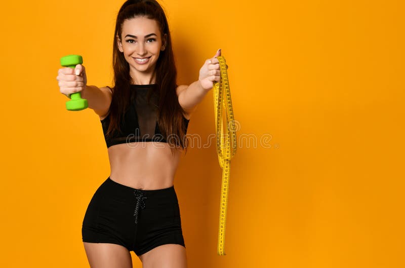 Photo de femme musculaire dans les vêtements de sport sur le fond jaune photographie stock libre de droits Photo de femme musculaire dans les vêtements de sport sur le fond jaune photographie stock libre de droits
