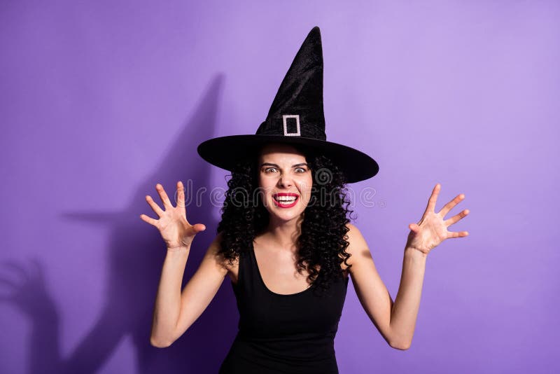 Photo of young beautiful attractive spooky witch girl scaring you wear cone shape hat isolated on purple color background. Photo of young beautiful attractive spooky witch girl scaring you wear cone shape hat isolated on purple color background.