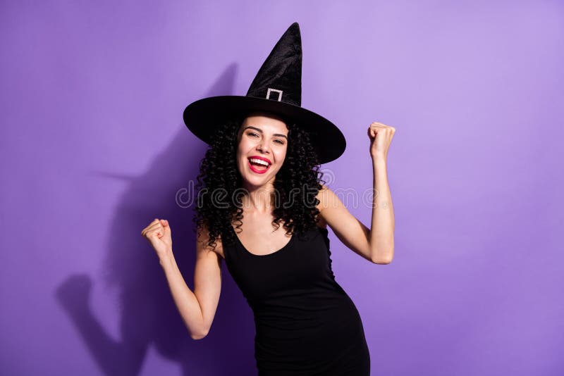 Photo of young beautiful cheerful excited witch girl raise fists in victory success isolated on purple color background. Photo of young beautiful cheerful excited witch girl raise fists in victory success isolated on purple color background.