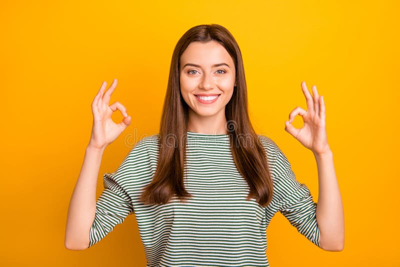 Photo de la femme magnifique avec du charme nous donnant le double signe correct tandis que d'isolement avec le fond jaune photos stock Photo de la femme magnifique avec du charme nous donnant le double signe correct tandis que d'isolement avec le fond jaune photos stock