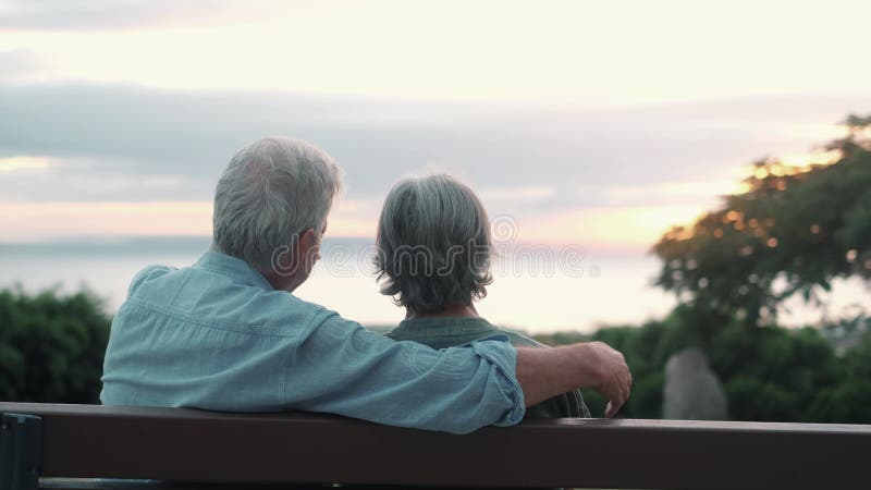 Photo de la tête gros portrait femme d'âge moyen aux cheveux gris heureux avec un mari plus âgé s'asseyant sur le banc du parc. co banque de vidéos