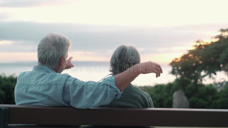 Photo de la tête gros portrait femme d'âge moyen aux cheveux gris heureux avec un mari plus âgé s'asseyant sur le banc du parc. co banque de vidéos