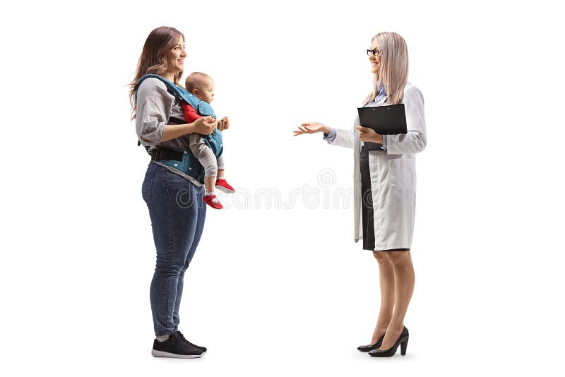 Photo de profil d'une gynécologue qui parle à une mère avec un bébé dans un porteur photo libre de droits