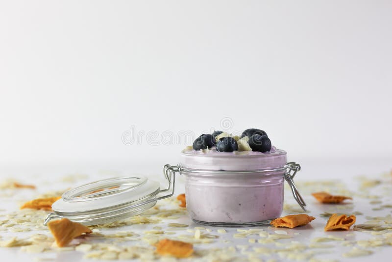 Photo de yaourt de myrtille, avec des canneberges et des amandes sur l'ardoise noire avec le fond blanc photo libre de droits Photo de yaourt de myrtille, avec des canneberges et des amandes sur l'ardoise noire avec le fond blanc photo libre de droits