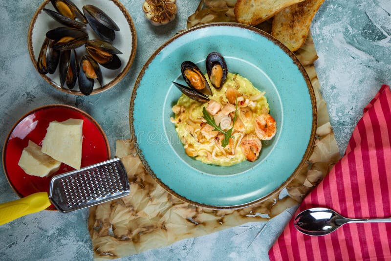 Photo of Delicious Risotto with Saffron and Seafood on Table. Stock