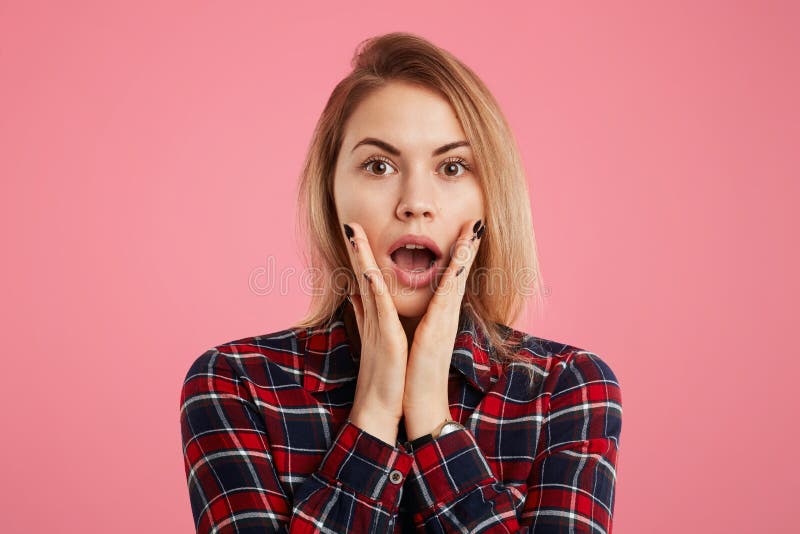 Photo of embarrassed female with stylish hairdo, manicure, looks with terrified expression, expresses her suprisment and shock, we stock photography Photo of embarrassed female with stylish hairdo, manicure, looks with terrified expression, expresses her suprisment and shock, we stock photography