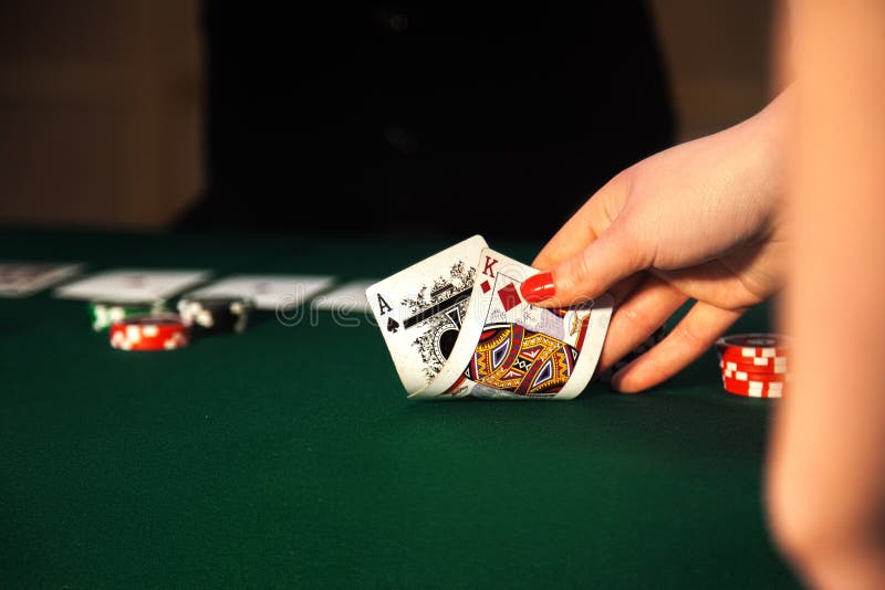 Photo en gros plan de la main femelle qui soulève des cartes de la table photographie stock Photo en gros plan de la main femelle qui soulève des cartes de la table photographie stock