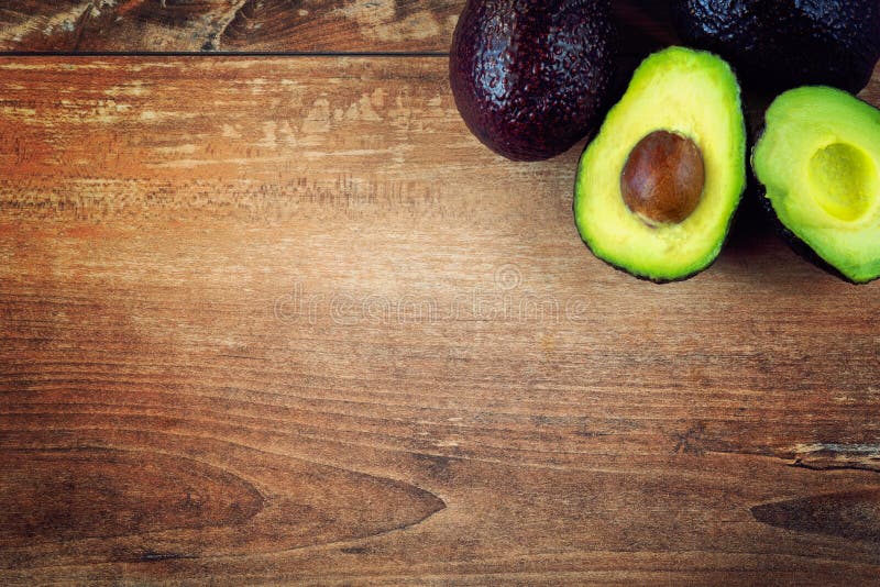 Photo en gros plan des avocats coupés en tranches frais, graines brunes évidentes sur le fond en bois brun image stock Photo en gros plan des avocats coupés en tranches frais, graines brunes évidentes sur le fond en bois brun image stock