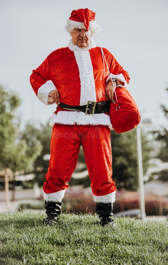 Photo en stock de la photo verticale de papa noel sans barbe, les bras se reposant sur le corps et se baignant Noël photo stock Photo en stock de la photo verticale de papa noel sans barbe, les bras se reposant sur le corps et se baignant Noël photo stock