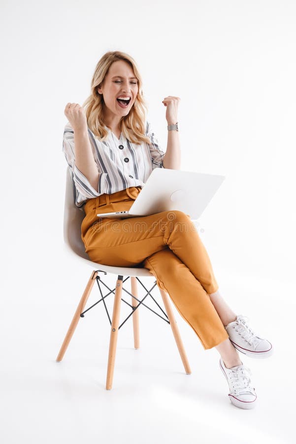 Photo of european happy woman wearing casual clothes using laptop while sitting in chair stock image Photo of european happy woman wearing casual clothes using laptop while sitting in chair stock image
